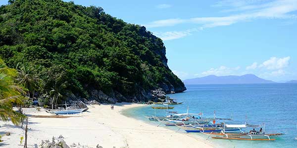 Puerto Galera, white sands and boats on the beach.